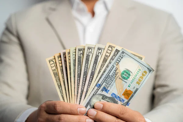 İş adamı ve paramızın tamamı kahverengi ceketli bir adama bağlı ve bana Amerikan Doları 'nı ver, Öde, Öde, beyaz arka planda değiş tokuş yap. İş finans ve banka çalışanı kavramı.