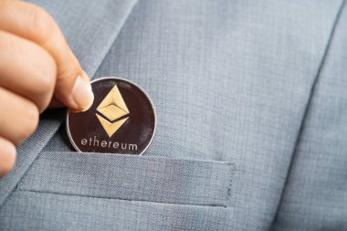 Altın Ethereum ETH takım elbise çantasındaki kripto para birimiyle birlikte iş adamı mavi takım elbise giyen parmaklarıyla topluyor. Bana güzel arka plandaki liflerin detaylarını ver.