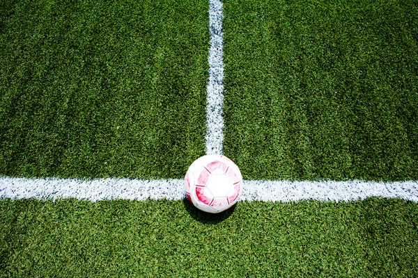 Pallone da calcio su striscia bianca campo verde — Foto Stock