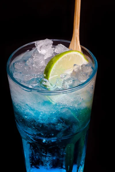 Glas blauer Cocktail mit Limette auf schwarzem Hintergrund — Stockfoto