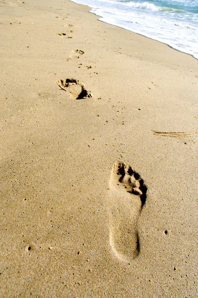 Tiro de pegadas na areia na praia — Fotografia de Stock