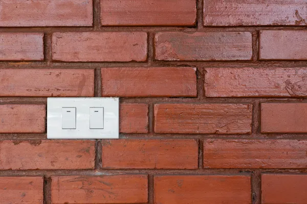 Light switch on red brick wall — Stock Photo, Image