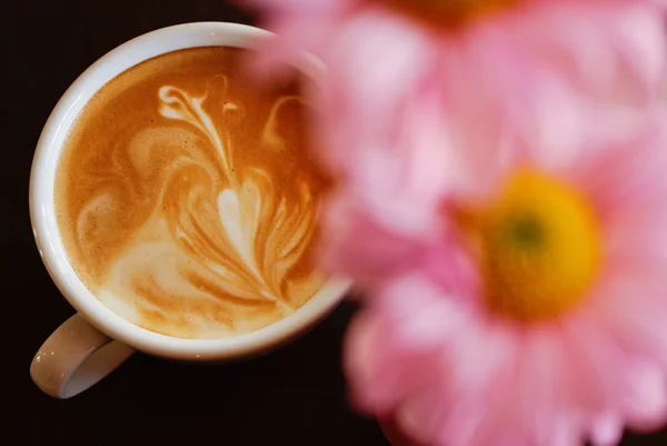 Tasse blanche de café avec fleur rose sur noir — Photo
