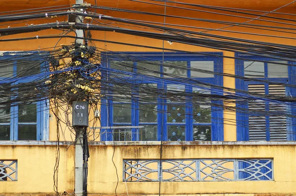 Um emaranhado de cabos e fios na frente da janela — Fotografia de Stock