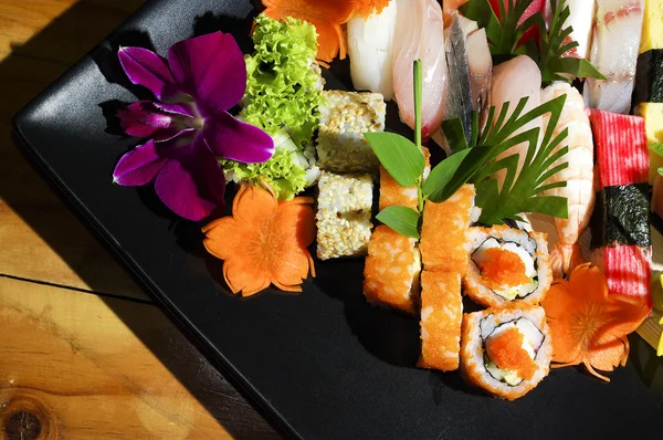 Assorted japanese sushi on a black plate. — Stock Photo, Image