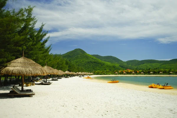 Hütte Sonnenschirm und Liegestühle am Sandstrand in der Nähe des blauen Meeres — Stockfoto