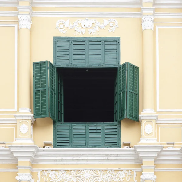 A janela verde aberta na parede amarela janela verde — Fotografia de Stock