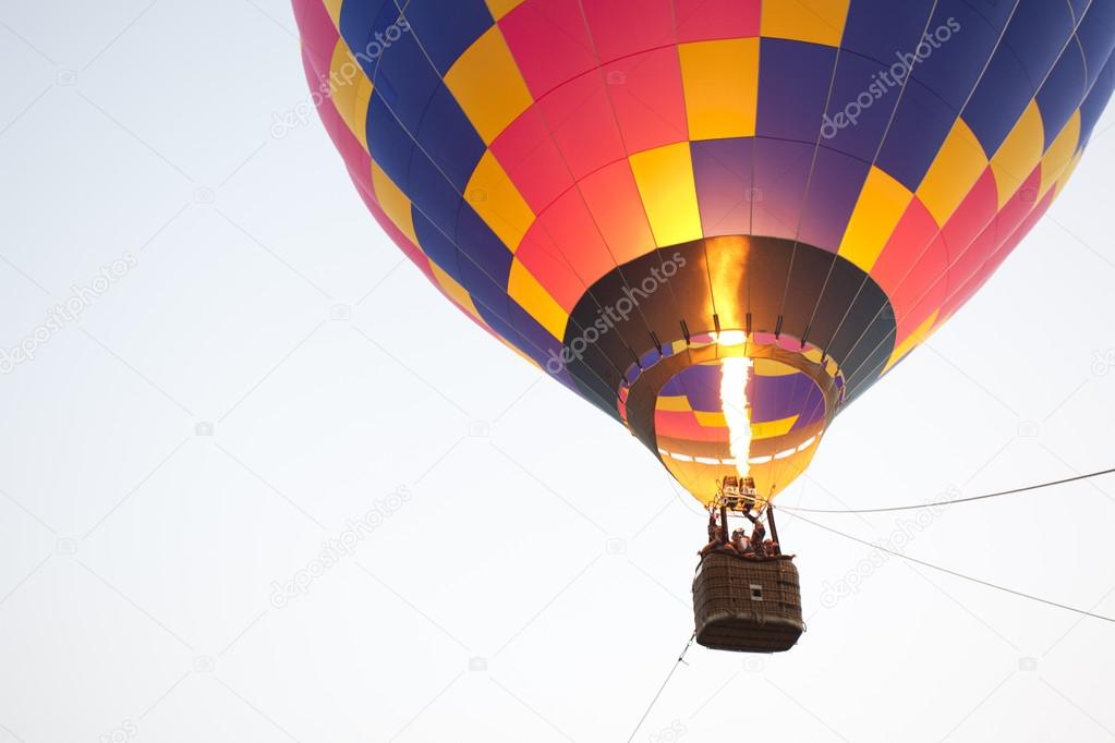 Silhouette hot air balloon landing with many