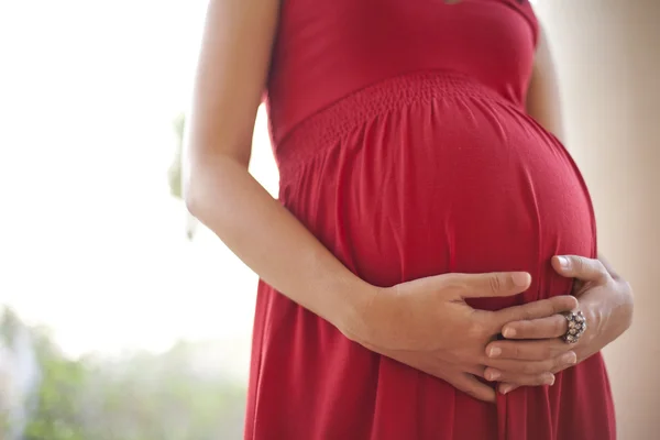 Bild einer schwangeren Frau, die ihren Bauch mit den Händen berührt — Stockfoto