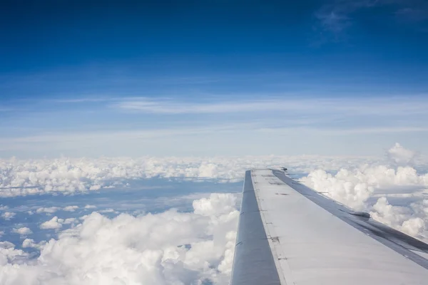 Ala de un avión volando por encima de las nubes. Mira la ventana. — Foto de Stock