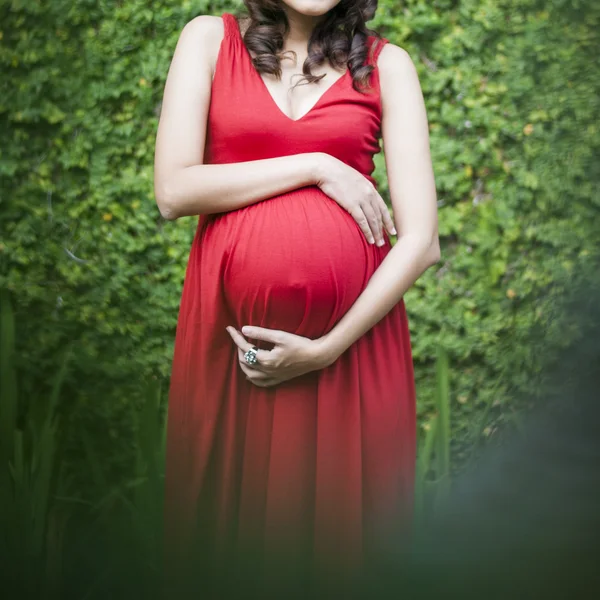 Image de la femme enceinte touchant son ventre avec les mains relaxantes o — Photo