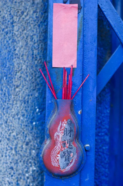Red chinese incense put on blue door front of house — Stock Photo, Image