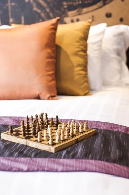 Chess on bed in hotel room clipart