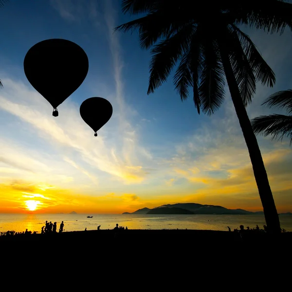 Ballon sur la plage tropicale avec des gens en silhouette — Photo