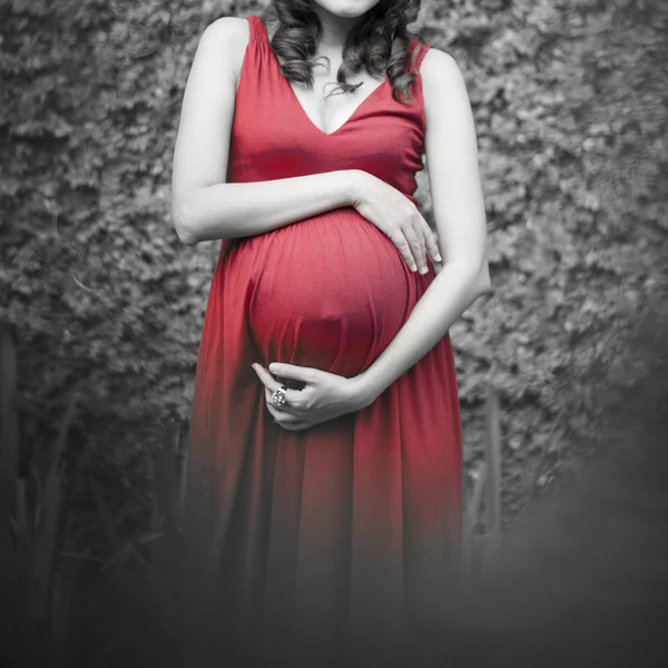 怀孕的女人，摸她的肚子放松以外在的手 — 图库照片