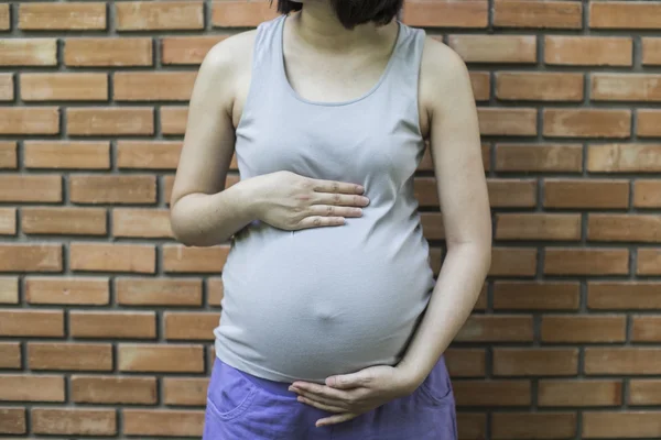 임신 여자와 그녀의 배꼽을 만져의 이미지 전면 o에 손 — 스톡 사진