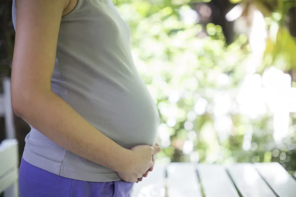 Bild einer schwangeren Frau, die ihren Bauch mit den Händen berührt — Stockfoto