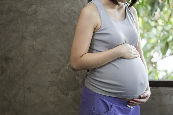 Bild einer schwangeren Frau, die ihren Bauch mit den Händen berührt — Stockfoto