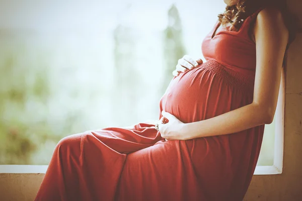 Imagen de una mujer embarazada tocándose el vientre con las manos — Foto de Stock