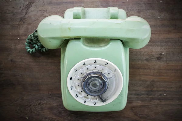 Groene vintage telefoon op bruin houten bureau achtergrond — Stockfoto