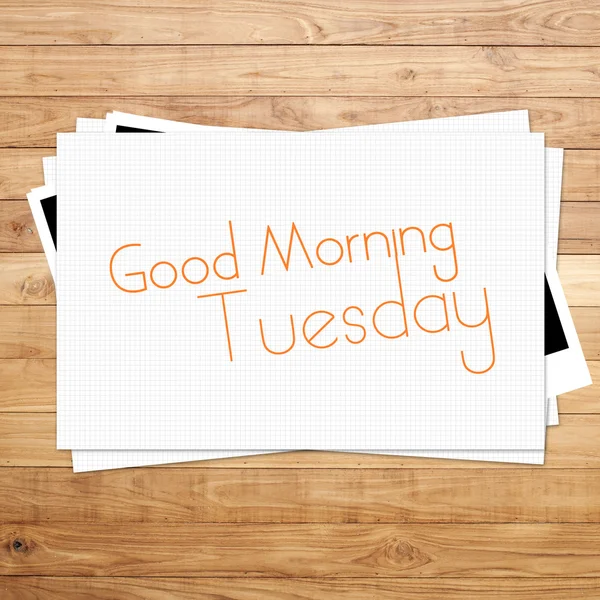 Goedemorgen dinsdag op papier en bruin hout plank achtergrond — Stockfoto
