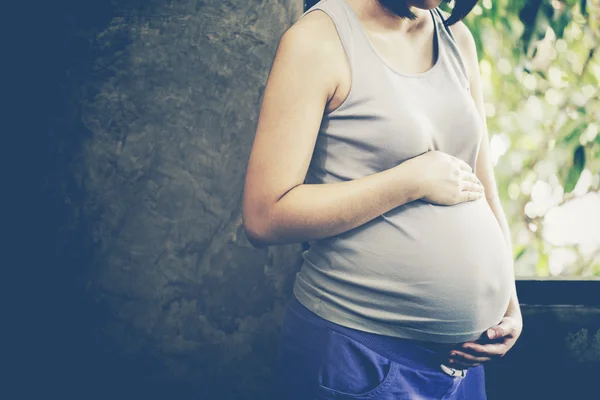 Bild einer schwangeren Frau, die ihren Bauch mit den Händen berührt — Stockfoto