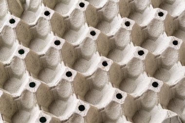 Boş yumurta tepsisi dokusu. Tavuk yumurtaları için geniş bir karton konteynır arka planı. Kırılgan tavuk yumurtaları için tekrar eden desenli biyolojik çözünebilir kağıt ambalajlar. Tam kare. Üst görünüm.