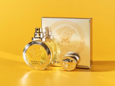Varna, Bulgaristan, Ekim 04, 2021. Versace Eros Femme parfüm şişesi ve parlak sarı arka planda ambalaj kutusu. Gianni Versace lüks moda şirketi tarafından üretilen şık bir parfüm..