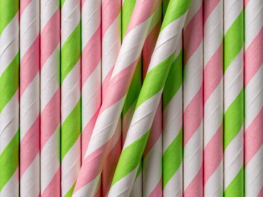 Parlak çizgili kokteyl kağıdı pipet arka plan. Tek kullanımlık pembe yeşil içme tüplerinin makro dokusu. Parti için çevre dostu renkli pipetler. Sıfır israf, plastik kavramları durdurun. Üst görünüm.