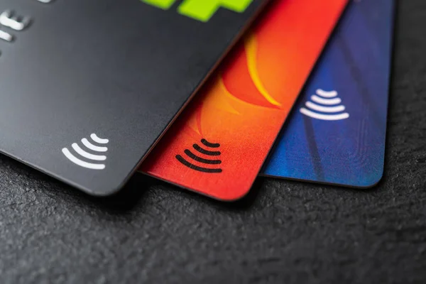 ブラック バックグランド マクロに非接触決済技術を搭載した3枚のクレジットカード お金の引き出しのためのデビットカード チャージカードによる商品やサービスの支払い Dof — ストック写真