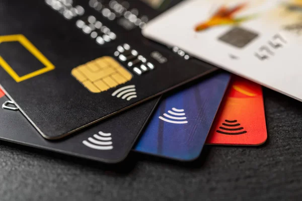 黑色背景的银行卡很少 采用非接触式支付技术的信用卡 提取现金时借记卡 货物和服务付款收费卡 浅色Dof — 图库照片
