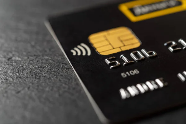 非接触技術と黒の背景マクロ上のチップを持つデビットカード 商品やサービスの支払いのためのブラッククレジットカード 銀行のプラスチックカードによる現金引き出し Dof — ストック写真