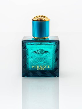 Varna, Bulgaria, December 25, 2021. Versace Eros perfume in a rectangular blue glass bottle on a white background. Stylish men perfume produced by Gianni Versace luxury fashion company. Front view.