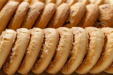 Ekmek arası çıtır bisküviler makro arka plan. Bir sıra lezzetli tereyağlı kurabiye ve yakın plan şeker. Kahvaltı için fırında hamur işi. Tatlı yemek, tatlı ve atıştırmalık şeyler. Ön görünüm.