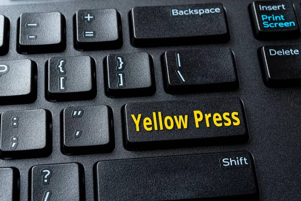 Yellow Press enter key on the black pc keyboard. Concept of disinformation, lies and hoax in the media. Spread false information on the Internet. Computer enter key with word message. Close-up.
