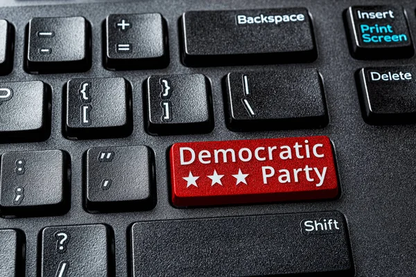 Democratic Party red key on a decktop computer keyboard. Concept of voting online for Democratic party, politics, United States elections. Laptop enter key with Democratic Party word message. Top view.