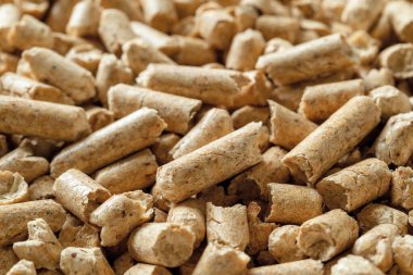 Tahta topaklar makro arka plan. Sıkıştırılmış talaş taneciklerinin dokusu. Ev ısıtması için alternatif enerji. Sıkıştırılmış talaştan yapılan ekolojik biyoyakıt. Yenilenebilir enerji kavramı. Ön görünüm.