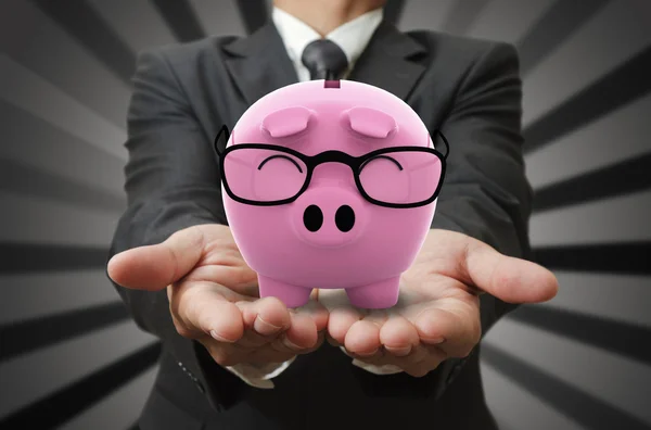 Zakenman toont een piggy bank — Stockfoto