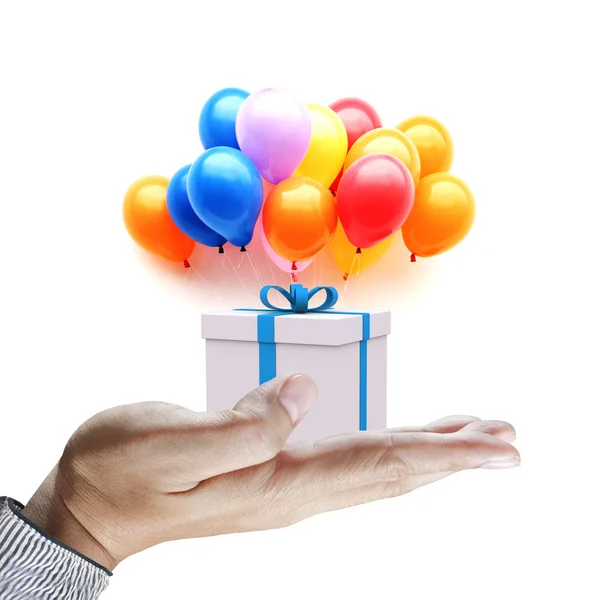 Hands holding gift in package with blue ribbon and colorful ball — Stock Photo, Image