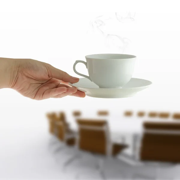 Coffee cup in woman hand on meeting table background — Stock Photo, Image