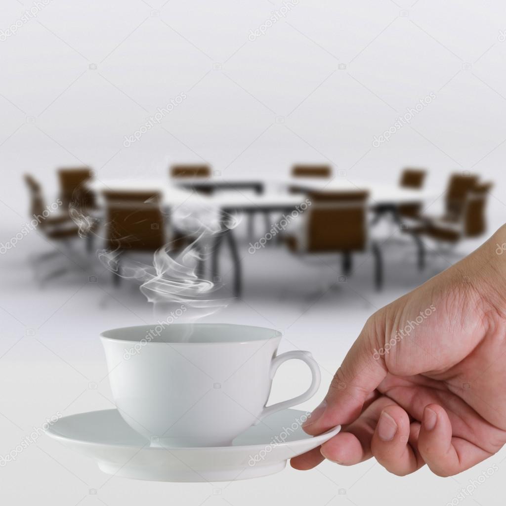 coffee cup in hand business and meeting room background