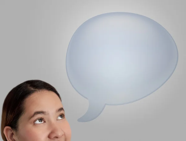 Mujer pensando en azul burbuja discurso en blanco sobre fondo gris . — Foto de Stock