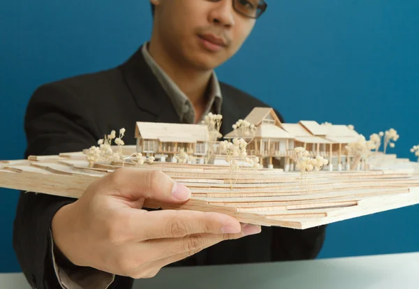 Man holding a model of a house in his hands. — Stock Photo, Image