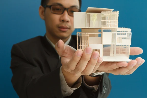 Man holding a model of a house in his hands. — Stock Photo, Image