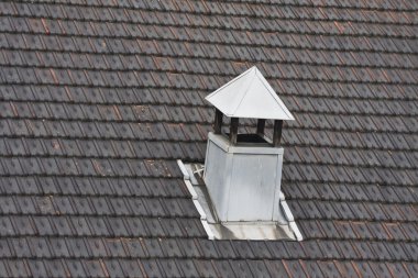 metal chimney on black tiled roof clipart