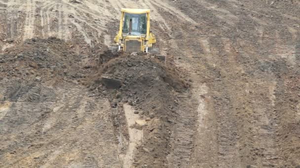 Gul bulldozer kratta lera — Stockvideo