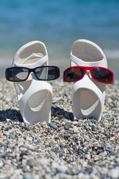 Zwei lustige Sandalen am Strand — Stockfoto