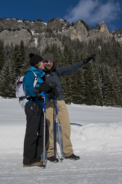 Un par de excursionistas señalando el camino en un sendero nevado —  Fotos de Stock