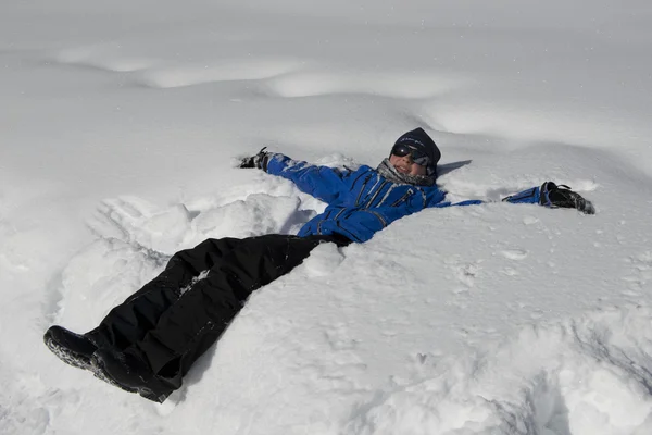 Teenager legt sich in den Schnee — Stockfoto