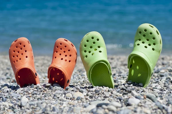 Zwei Paar Sandalen am Strand — Stockfoto